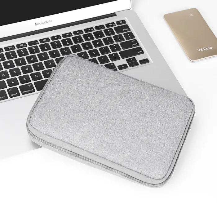 Closed gray zippered electronics pouch shown on a laptop